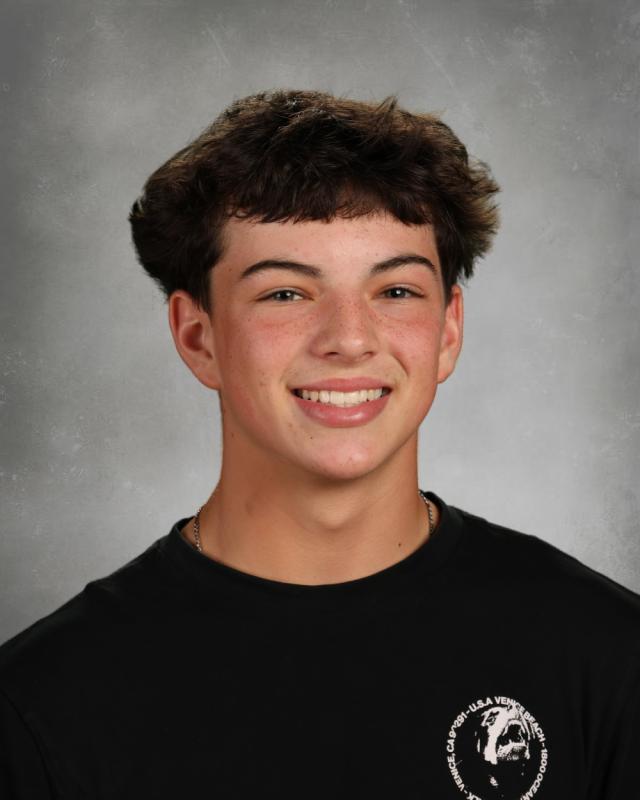 Portrait of Emmett Gray smiling in front of studio lighting